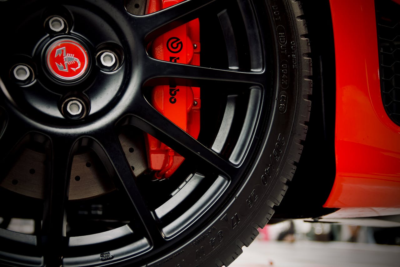 Detailed view of a black wheel and red Brembo brake on a sports car.