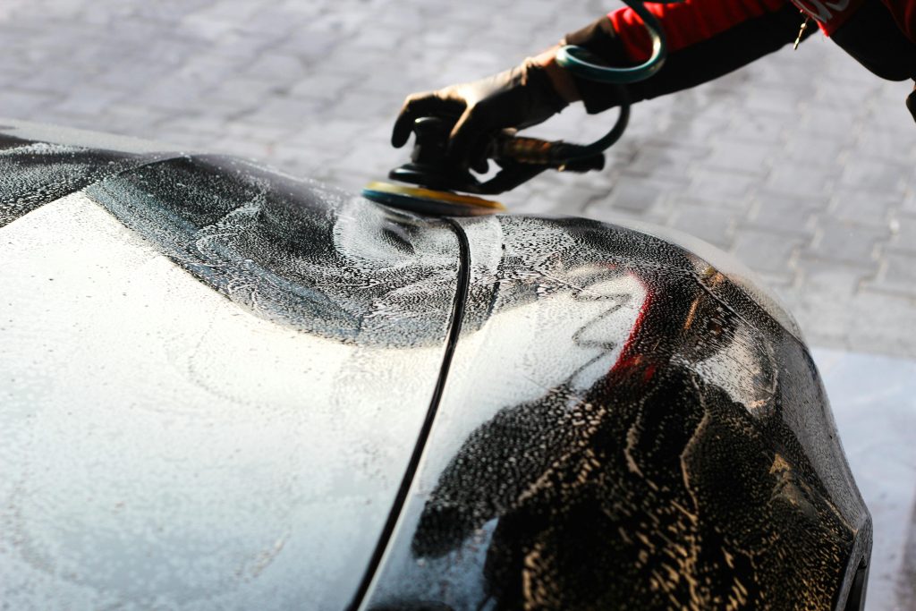 pexels photo 6026083 6026083 Close-up of a car being polished by hand, showcasing professional detailing and maintenance.