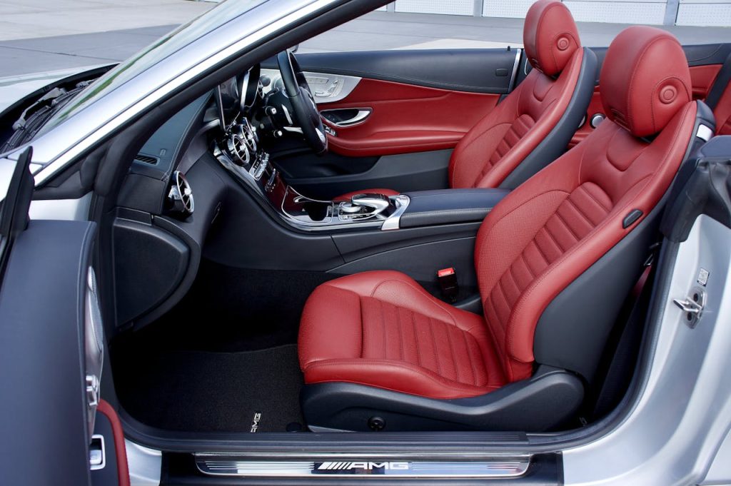pexels photo 8723327 Explore the elegance of a luxury car's red leather interior, showcasing sleek design and AMG branding.